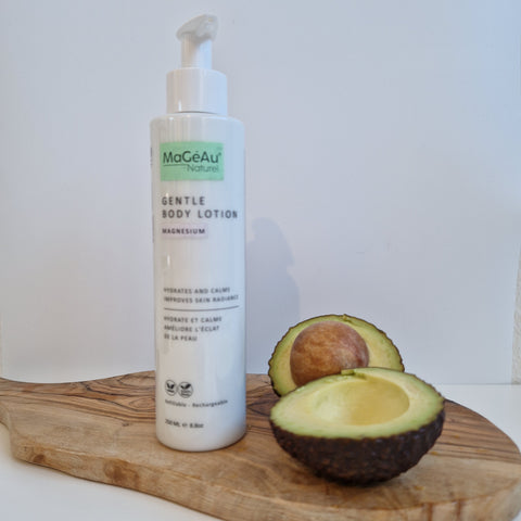 Mageau Magnesium Gentle Body Lotion bottle with an avocado on a wooden board